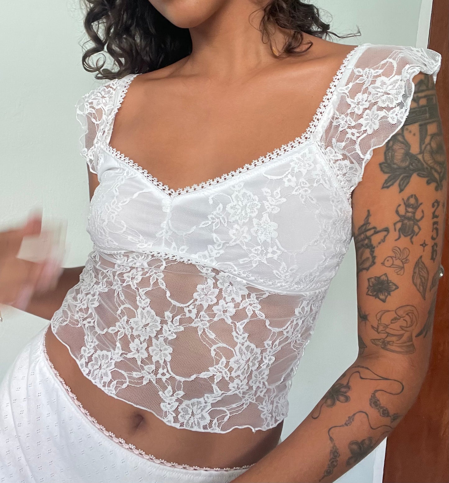 white lace camisole top with cap sleeves in a floral lace fabric and lined bust with sheer stomach